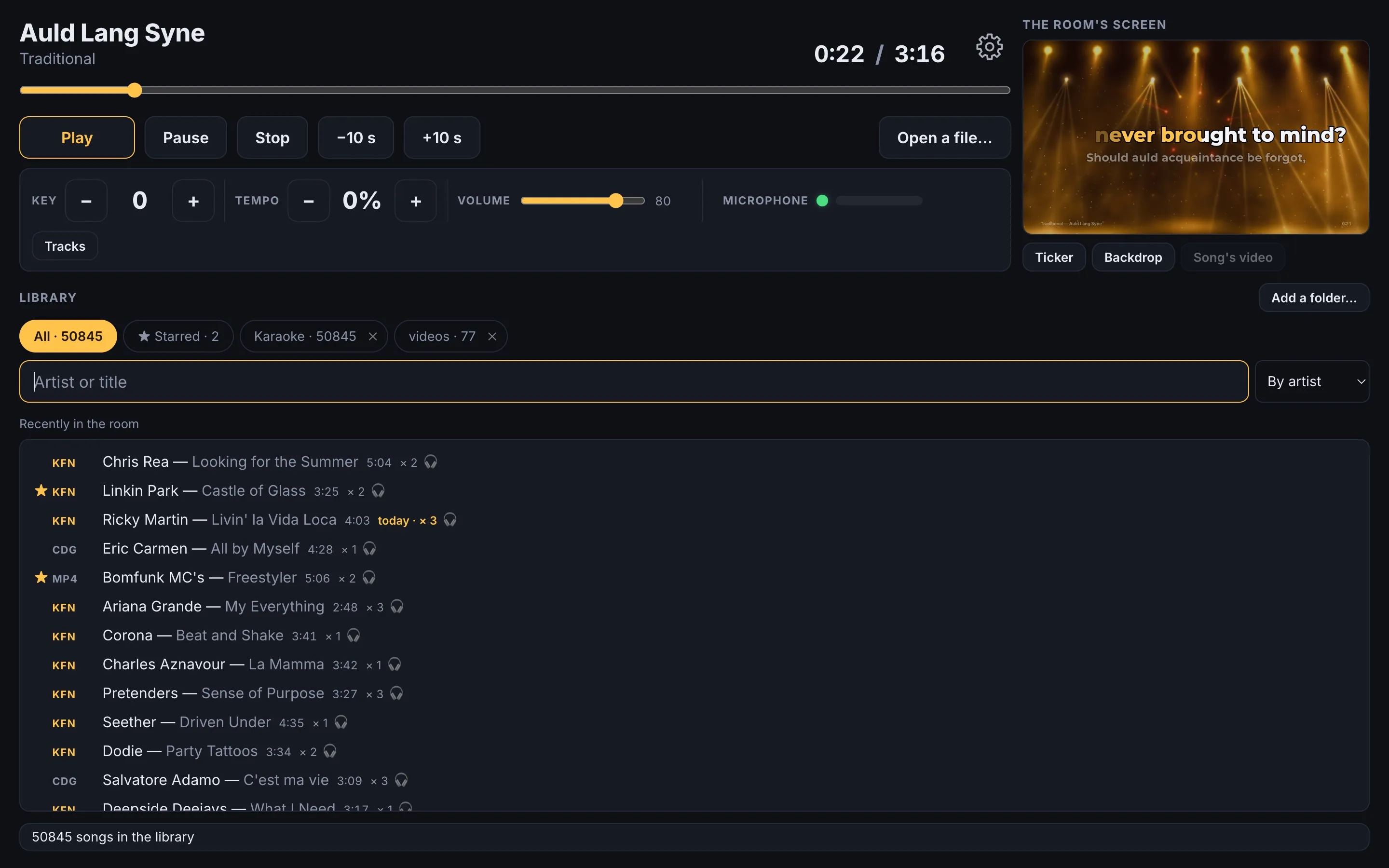 The RocketKaraoke console in home mode: the song, key, tempo, the microphone, the library and the room's screen in a small window