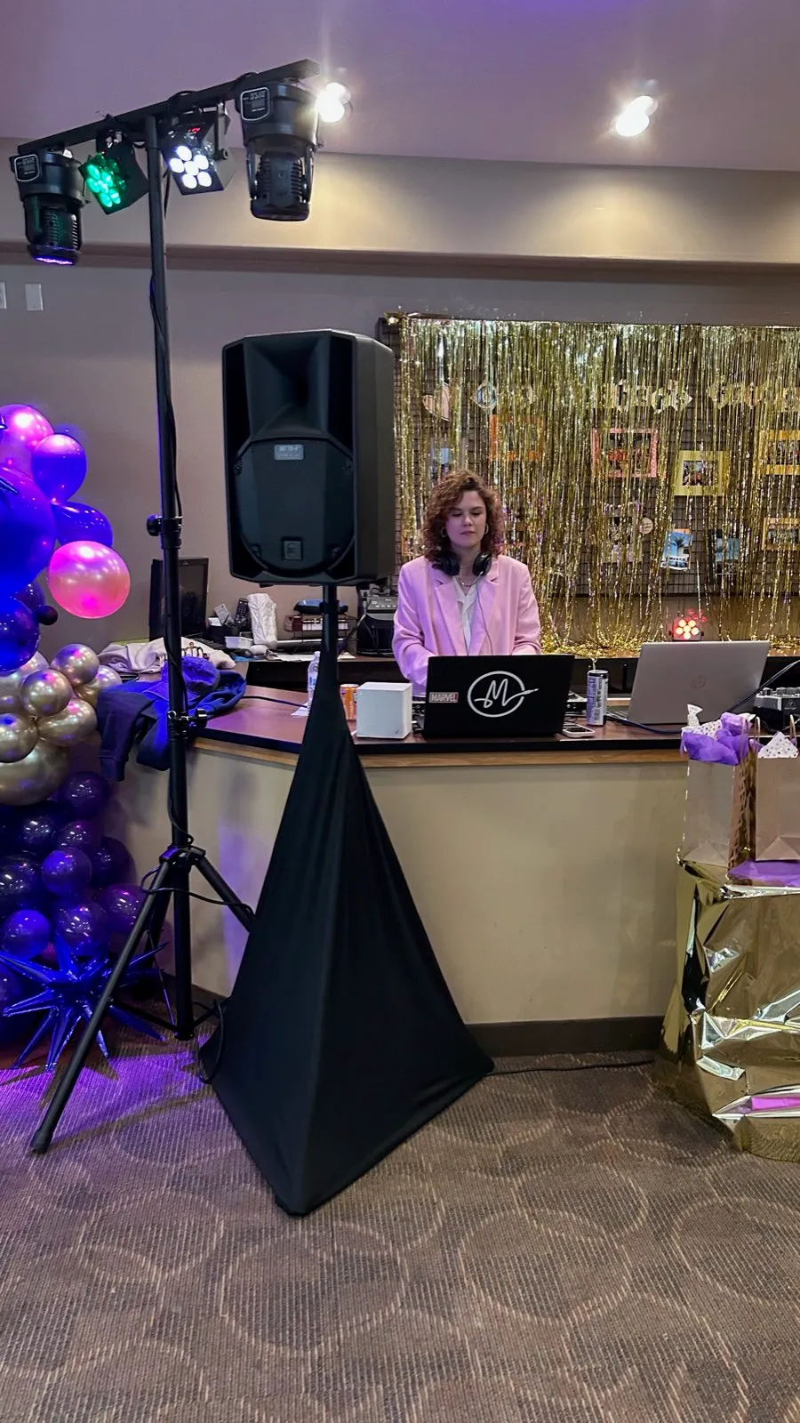 DJ booth with speakers and moving lights at an indoor birthday party