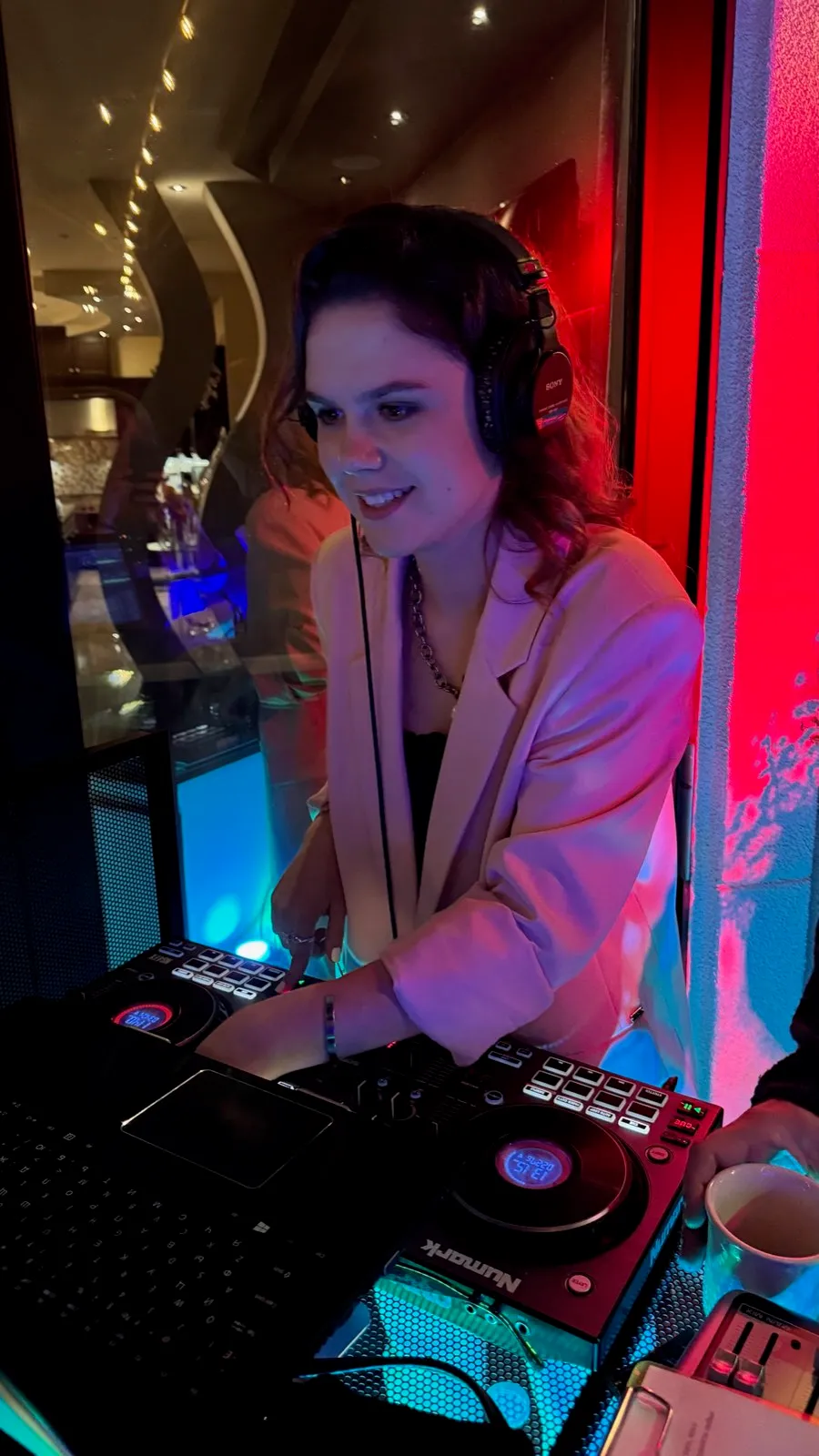 DJ mixing on the controller under colored lights at a Poway wedding reception