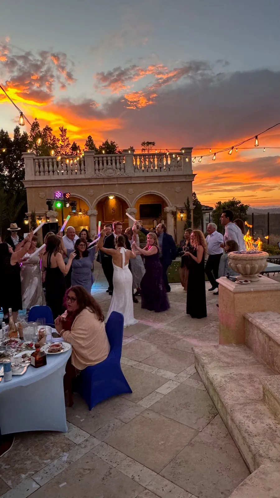 Wedding guests dancing at sunset by the fire pit at a Poway estate